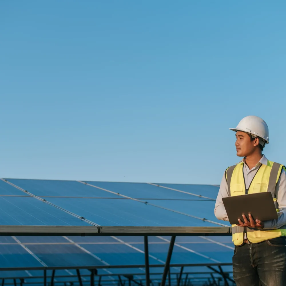 young-asian-inspector-engineer-man-use-laptop-computer-working-solar-farm-technician-supervisor-male-white-helmet-checking-operation-sun-photovoltaic-solar-panel-station-copy-space
